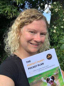 Carrie smiling and holding her puppy training guide ‘The Perfect Puppy Pocket Plan’ – expert dog trainer in Coventry
